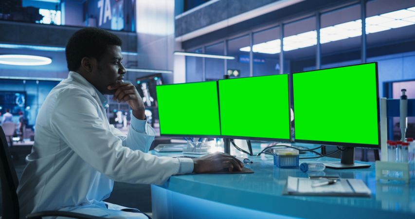 Cancer Research Center Medical Laboratory: Black Male Neuroscientist Using Desktop Computer With Green Screen Chromakey On Display.