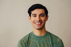 Portrait of happy Hispanic male in neutral room, copy space