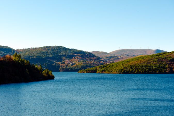 Calm river flowing between green hills