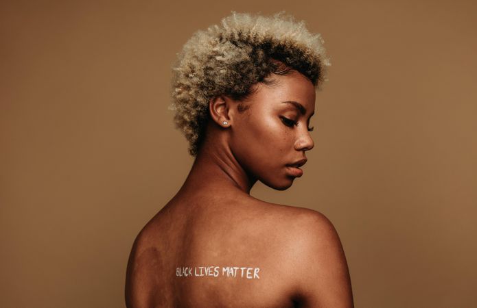 Black woman sending a strong message across with writing on her back