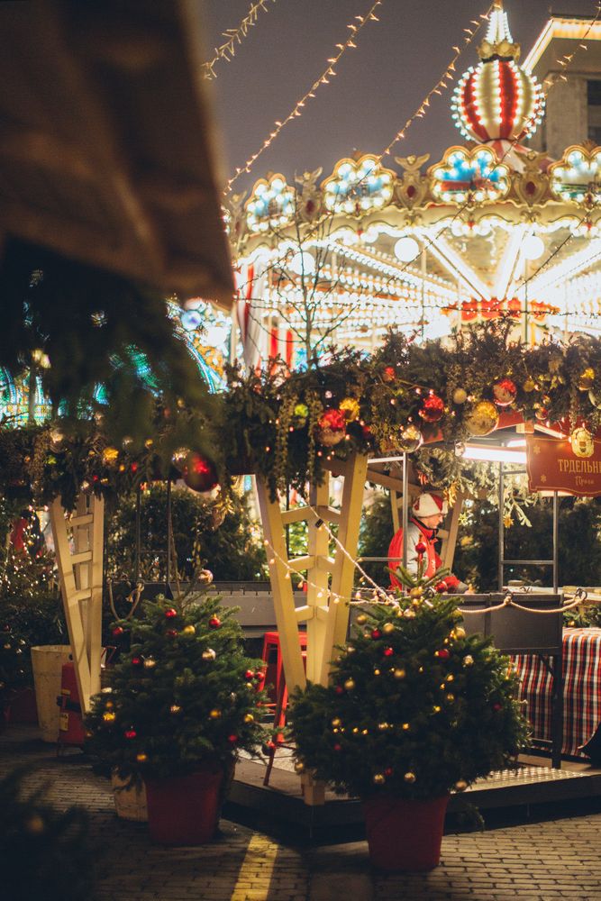 Lit carousel decorated with Christmas trees and light at night