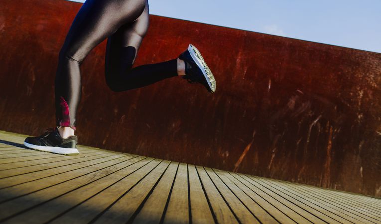Woman running on street in sunny day