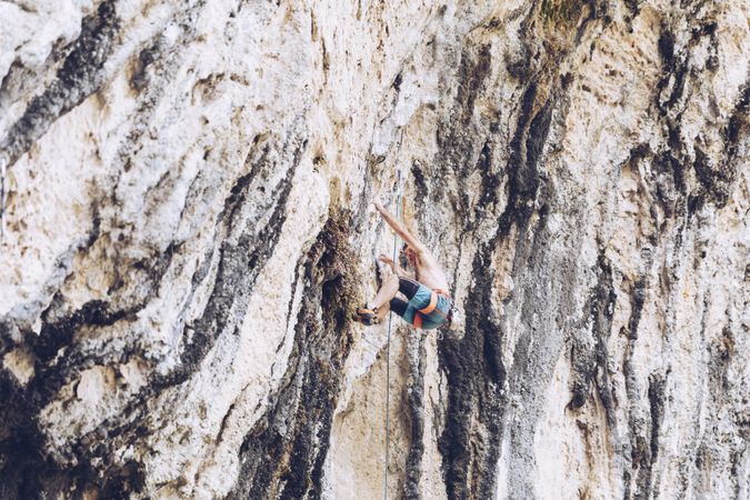 Anonymous man climbing rock