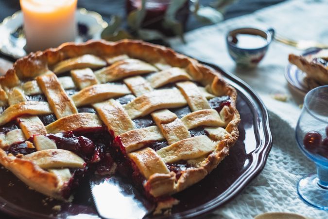 Cherry pie decorated with lattice topping on serving dish