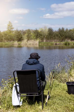 fishing rod on lake water background. Man catching fish by spinning on lakeside