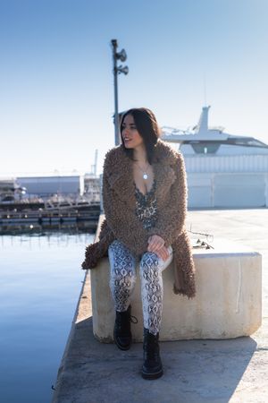 Stylish female sitting in harbor