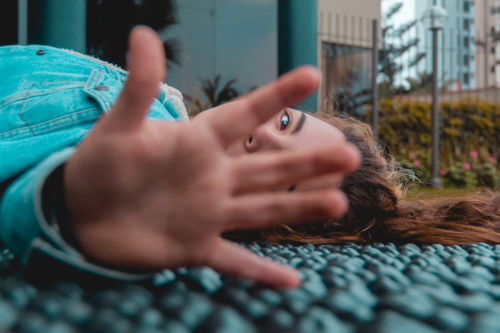 Woman lying on floor blocking view with her hand