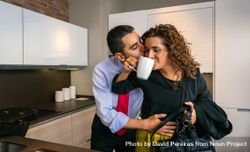 Businessman embracing and kissing woman while drinking fast cup of coffee before going to work 0vDEg4