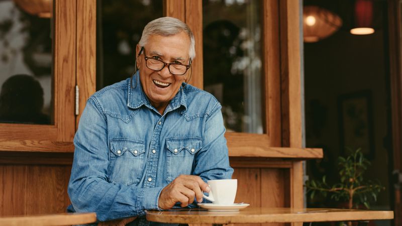Portrait of happy older man having coffee at coffeeshop