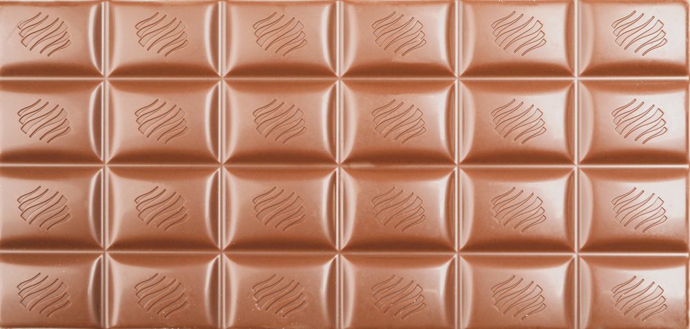 Different chocolate bars on whole background. Sweet food