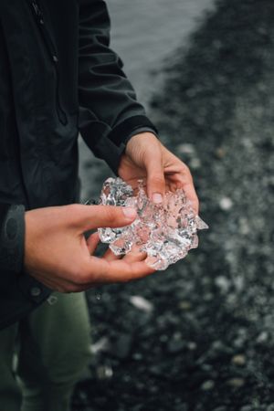 Person holding ice on cold day, vertical