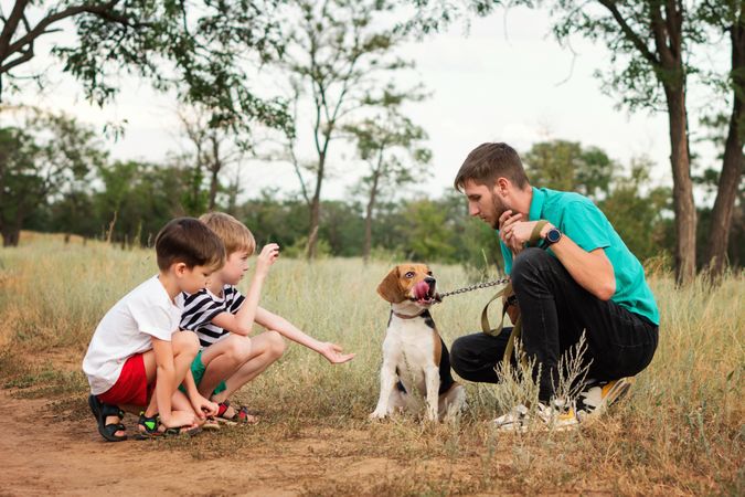 Father and two sons train dog