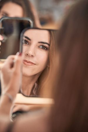 Woman looking at mirror in beauty salon