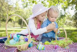 Cute Young Brother and Sister Enjoying Their Easter Eggs Outside
