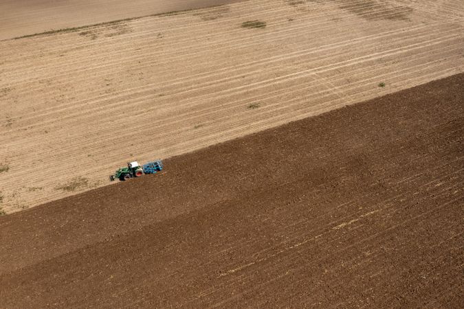 Aerial view of a single tractor plowing an agricultural field in Germany