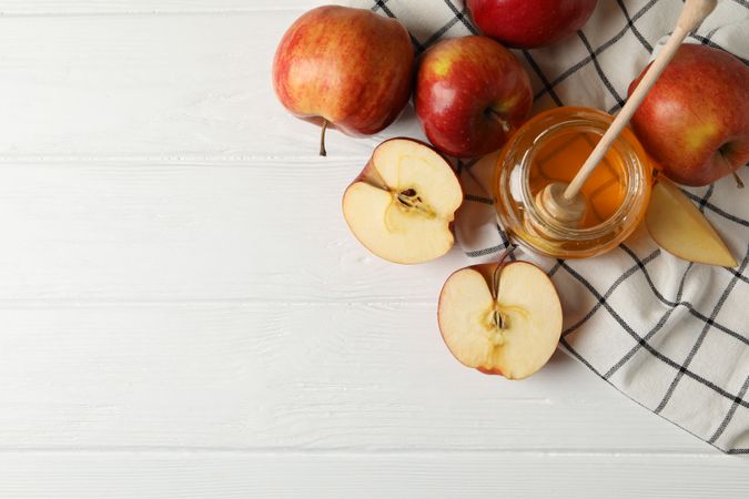 Top view of apples and honey on kitchen towel, with copy space