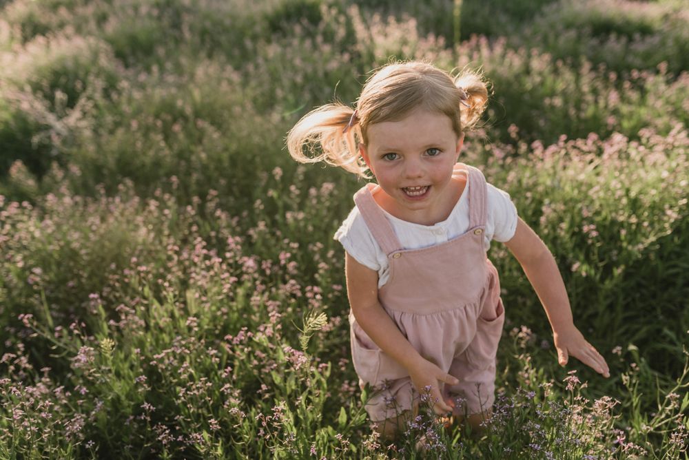 Girl standing in green field smiling