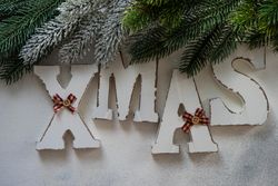 XMAS spelled in wooden letters with Christmas pine