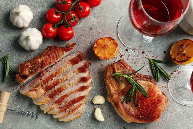 Composition with fried steaks, wine and vegetables. Grilled food