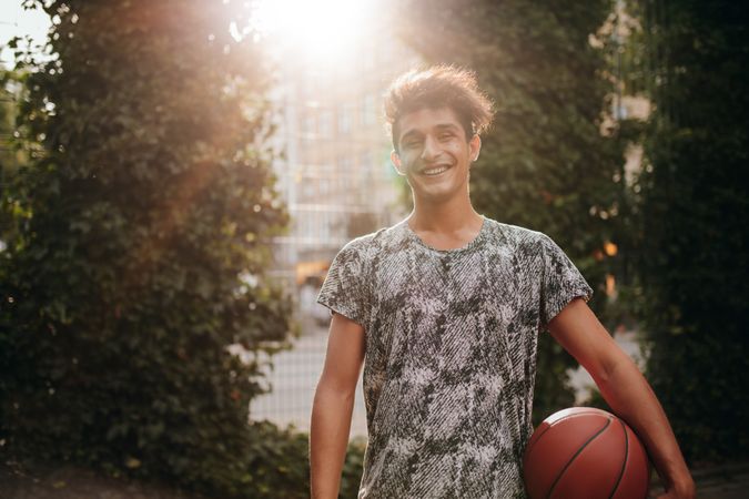 Handsome young basketball player with a ball