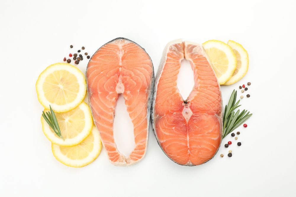 Fresh raw salmon meat and spices isolated on light background
