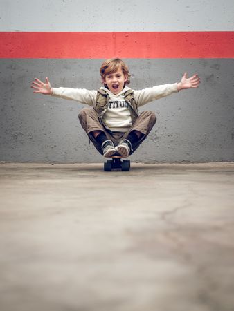 Funny child sitting on skateboard