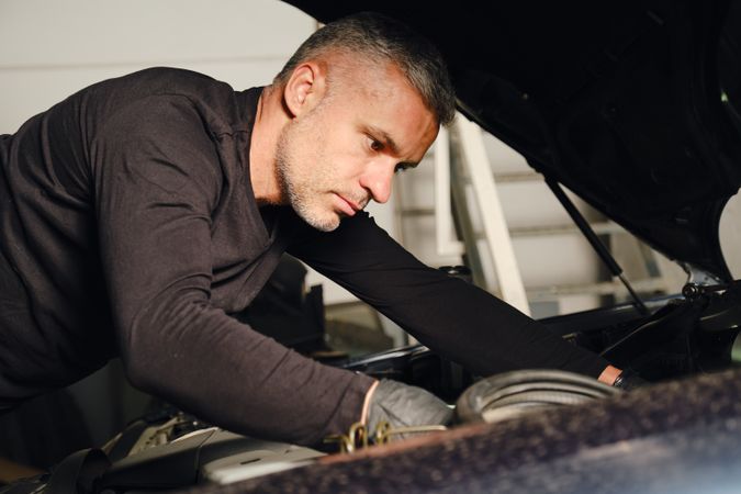 Mechanic fixing car engine in garage