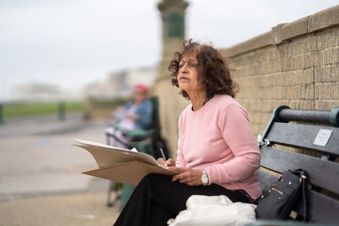 Indian woman sitting on bench drawing