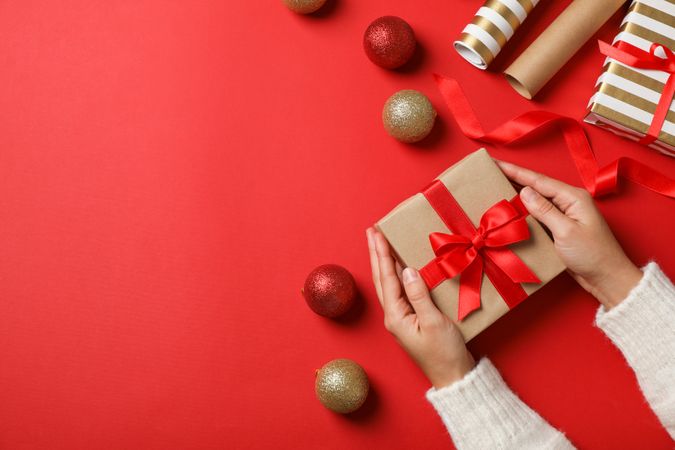 Female hands holding present on decorated background, copy space