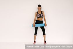 Woman in fitness studio with a yoga mat 4d8AVr