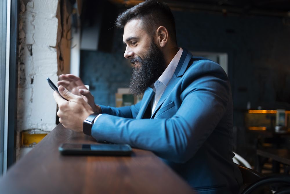 Man checking phone in pub