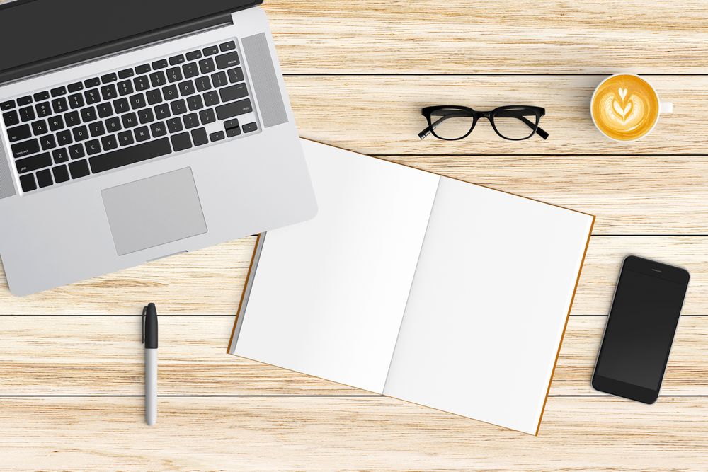 Modern workspace with coffee cup, smartphone, paper, notebook, tablet and laptop copy space