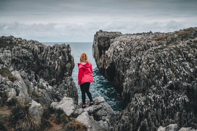 Female standing on cliff and contemplating