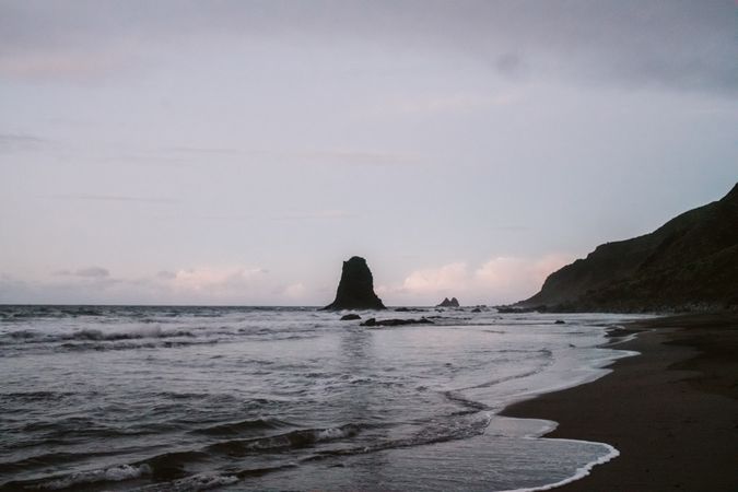 Lonely cliff in sea on cloudy day