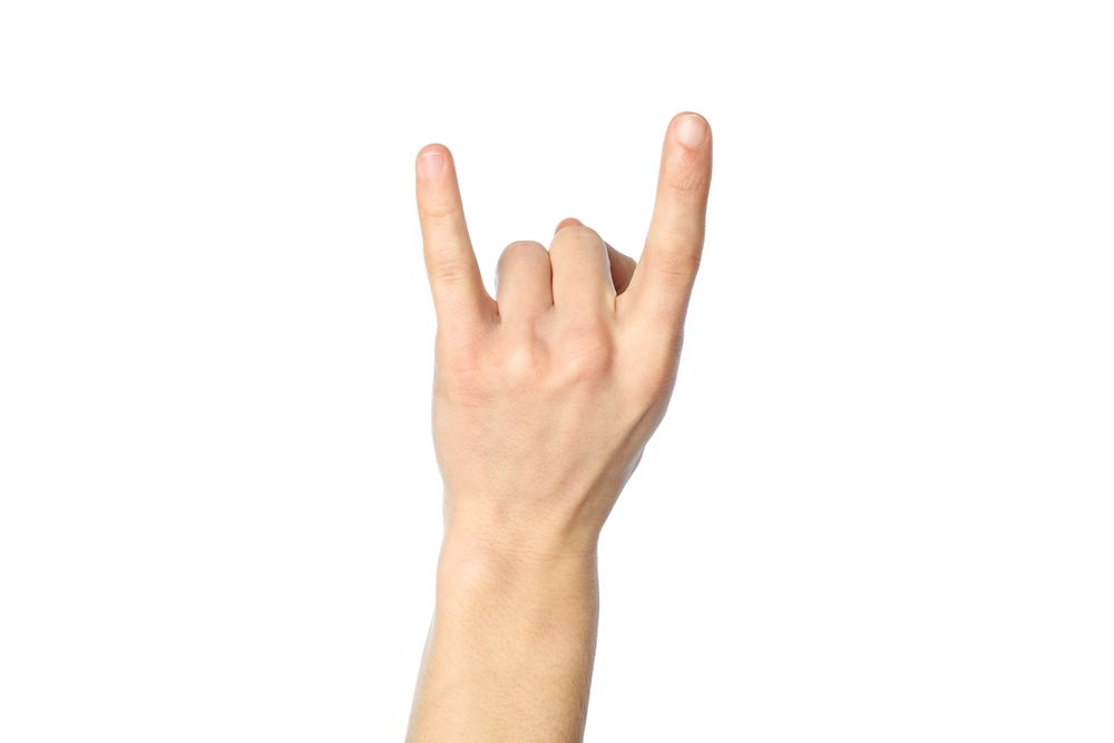 Male hand showing rock sign, isolated on plain background. Gestures