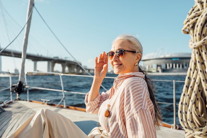 Older female enjoying vacation on a private sailboat