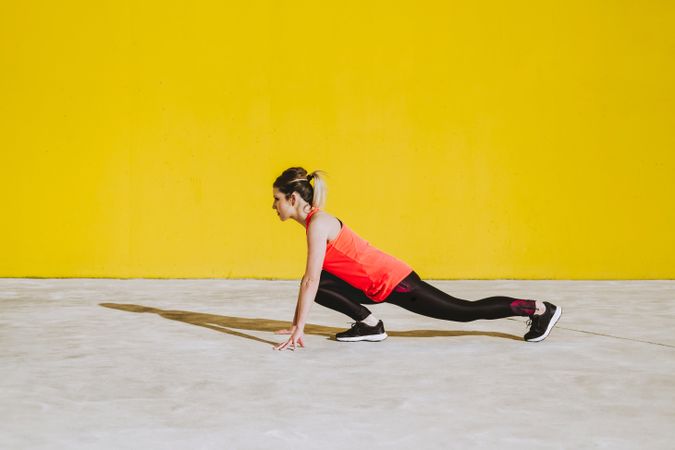 Woman stretching legs near wall
