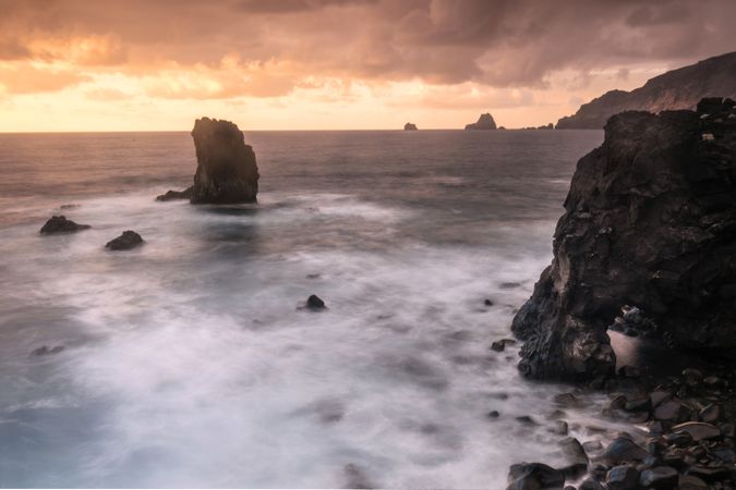 Amazing stone shore and pink sky with clouds