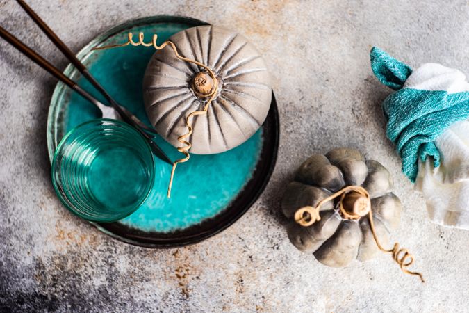 Top view of ceramic pumpkin decorations with teal tableware