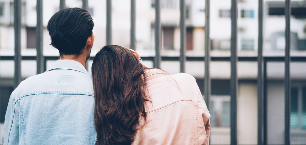 Back view of woman resting head on boyfriend's shoulder