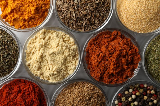 Top view close up of bowls of spice in rows