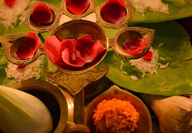 Rose petals on golden panch aarti on a table