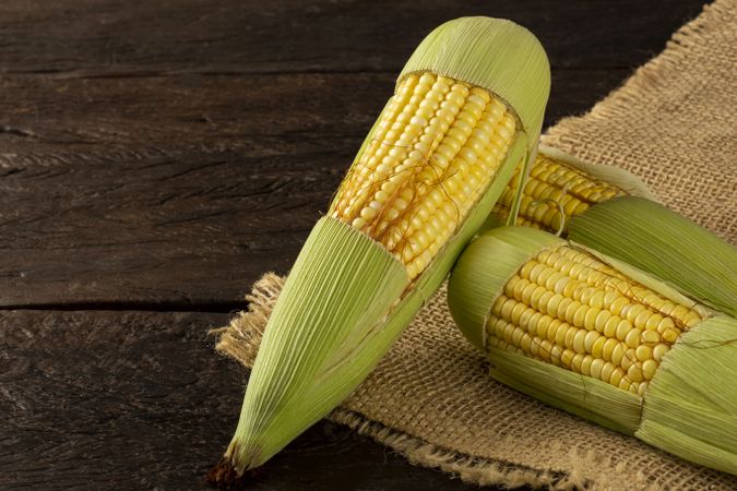 Green corn on the wooden table.