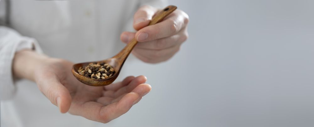 Man holding spoon with grains
