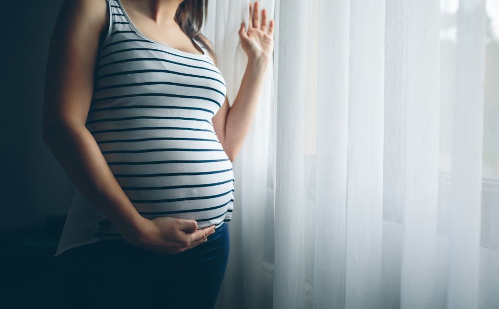 Unrecognizable pregnant holding her belly