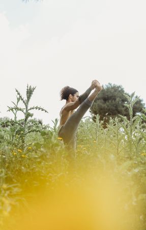 Man training yoga on meadow