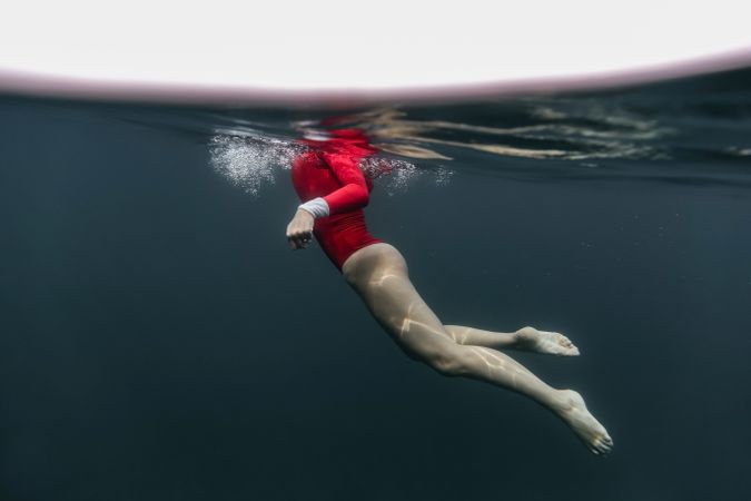 Woman diving in blue waving water