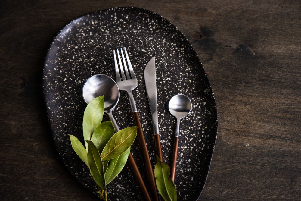 Rustic table setting with bay laurel leaves on wooden table