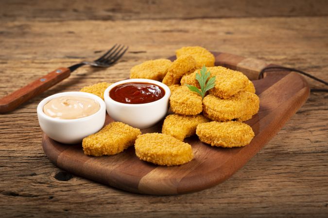 Fried chicken nuggets with ketchp and rose sauce.