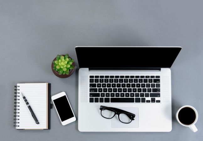 Flat lay view of gray desk with functional wireless technology and coffee drink